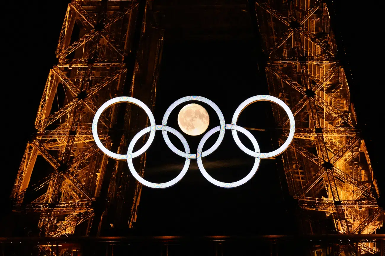 The moon rises behind the Olympic rings displayed on the Eiffel Tower in Paris on July 22, 2024, ahead of the Paris 2024 Olympic Games.