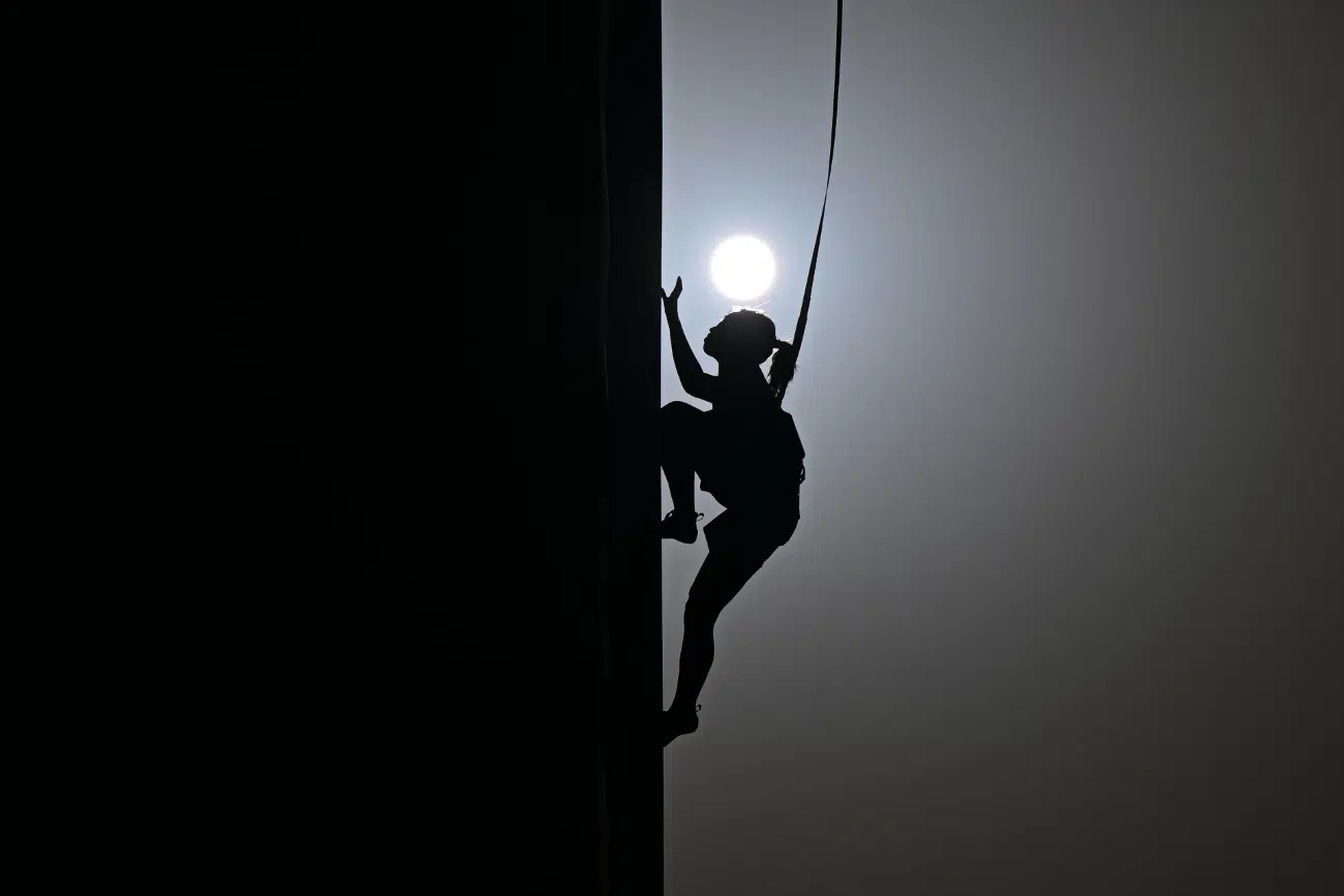 Black and white image of climber with sun in the background